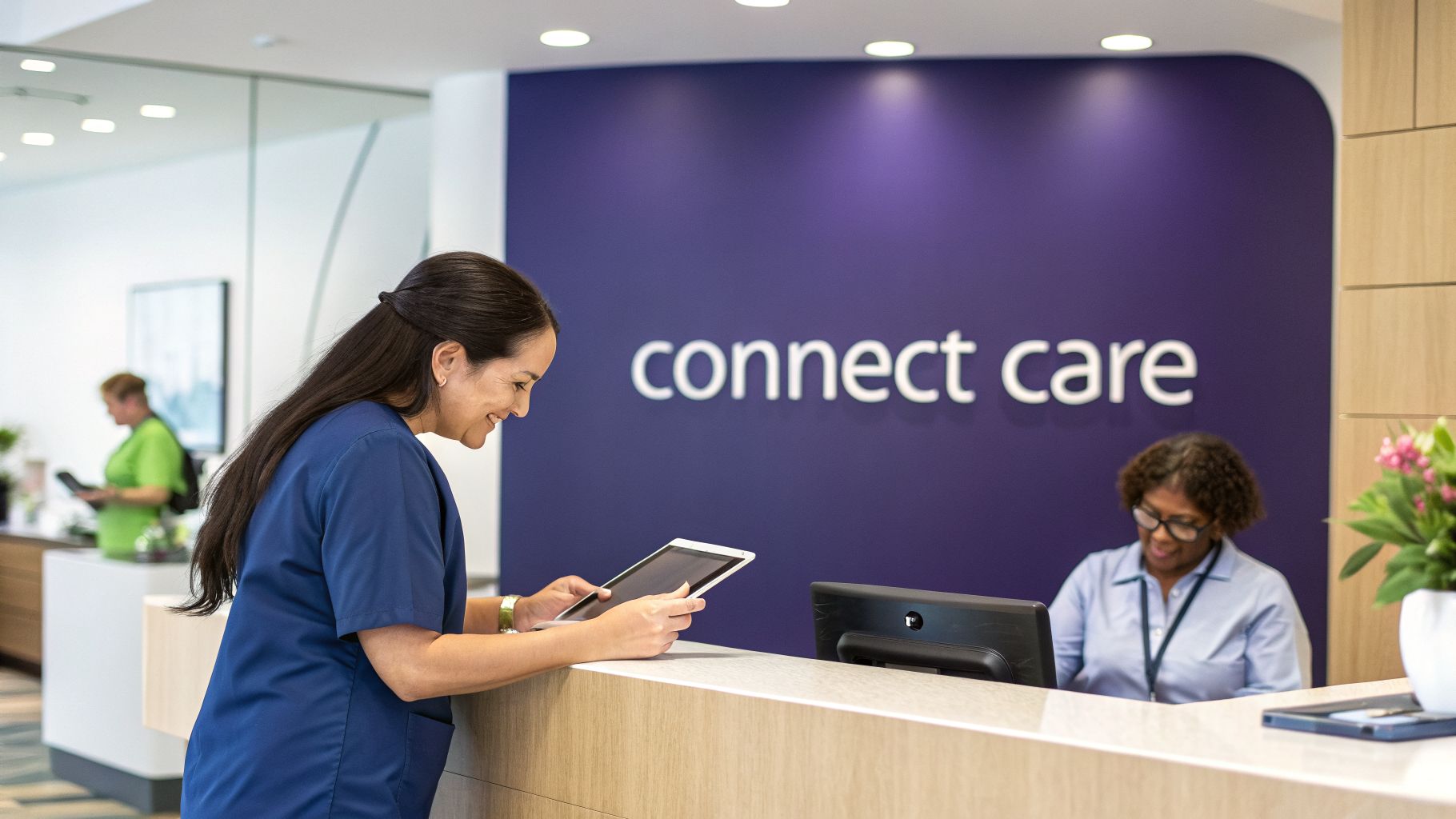 A smiling medical professional in blue scrubs uses a tablet at a modern clinic reception.