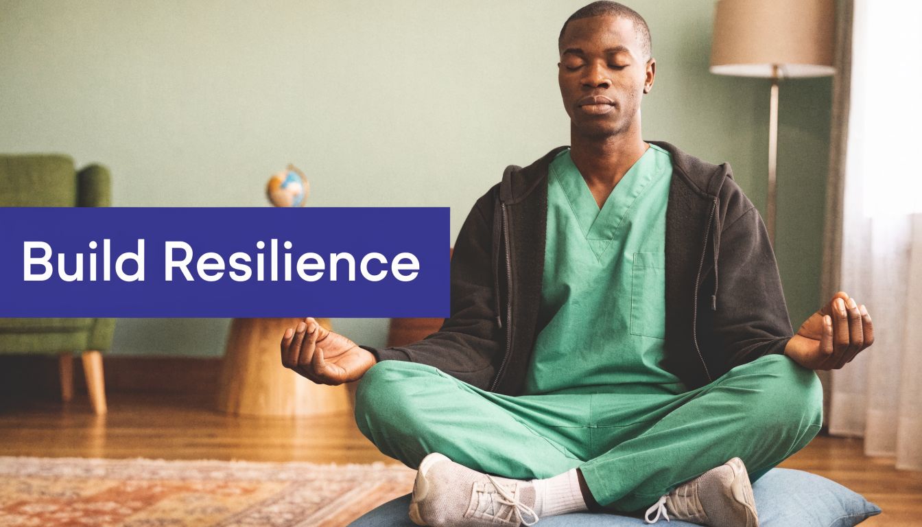 A healthcare professional in green scrubs sitting in a meditative pose to practice mindfulness and build resilience.