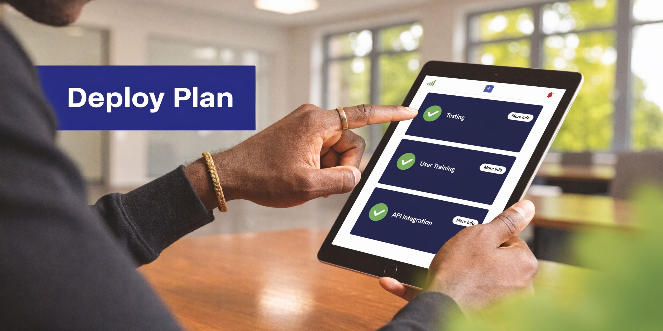 A professional using a tablet to review a project deployment plan with completed task statuses.