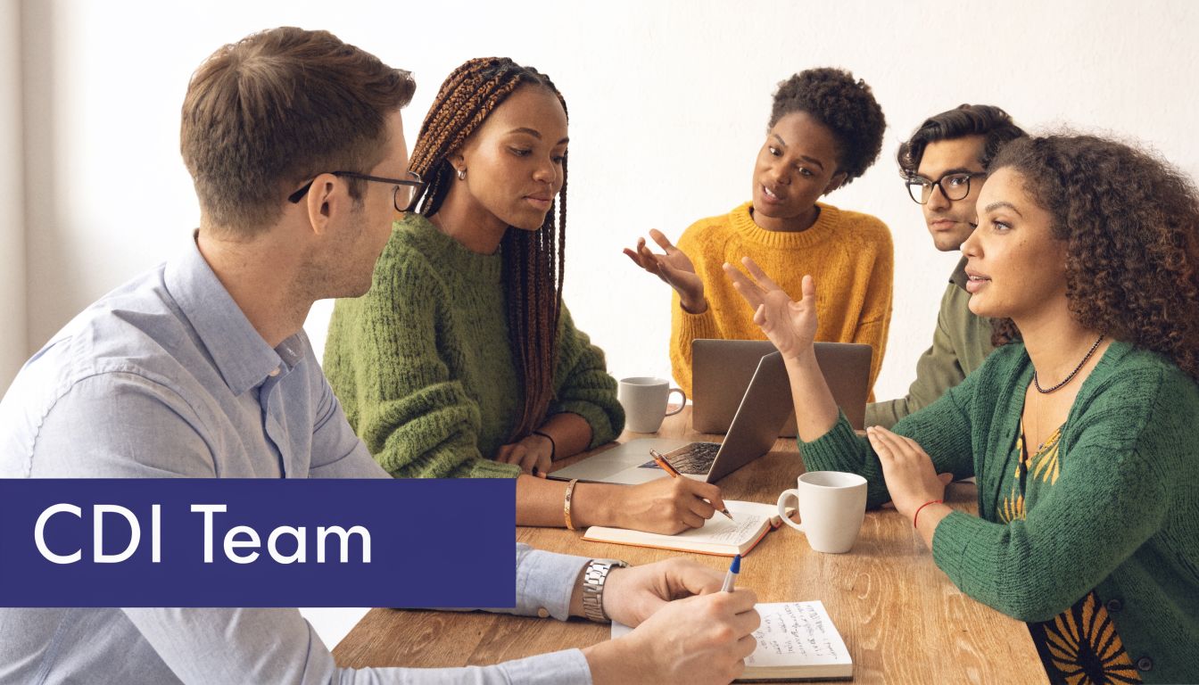 A diverse group of professionals working together collaboratively in an office meeting around a wooden table.