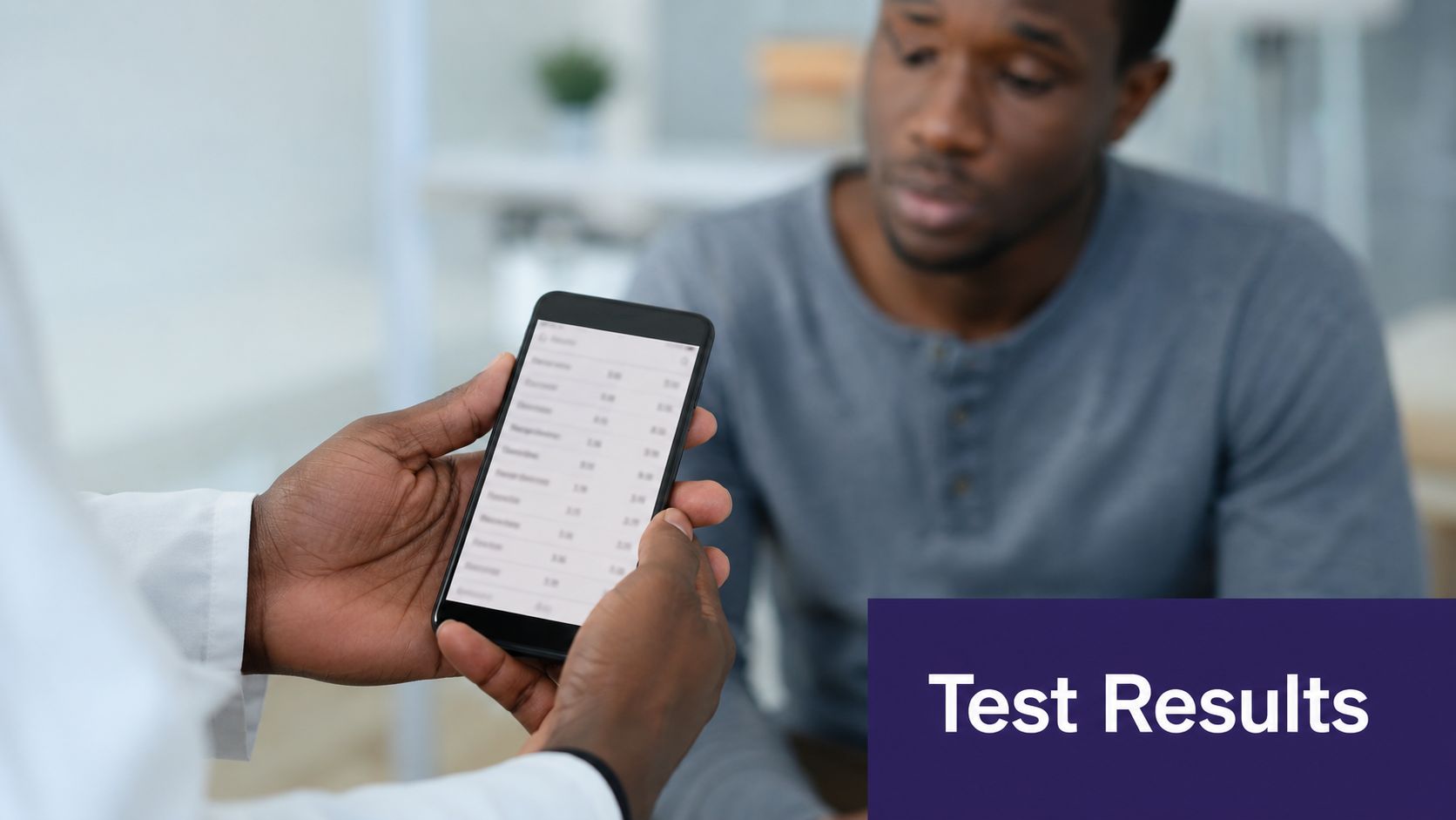 A doctor showing a patient health test results on a mobile phone during a medical consultation.