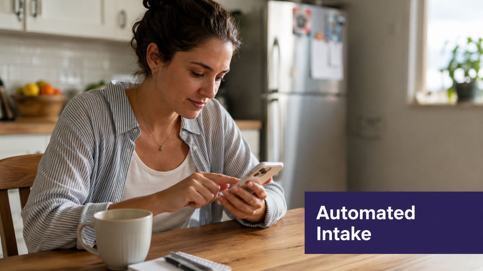 A woman sitting at a wooden kitchen table using her smartphone to manage health intake forms.